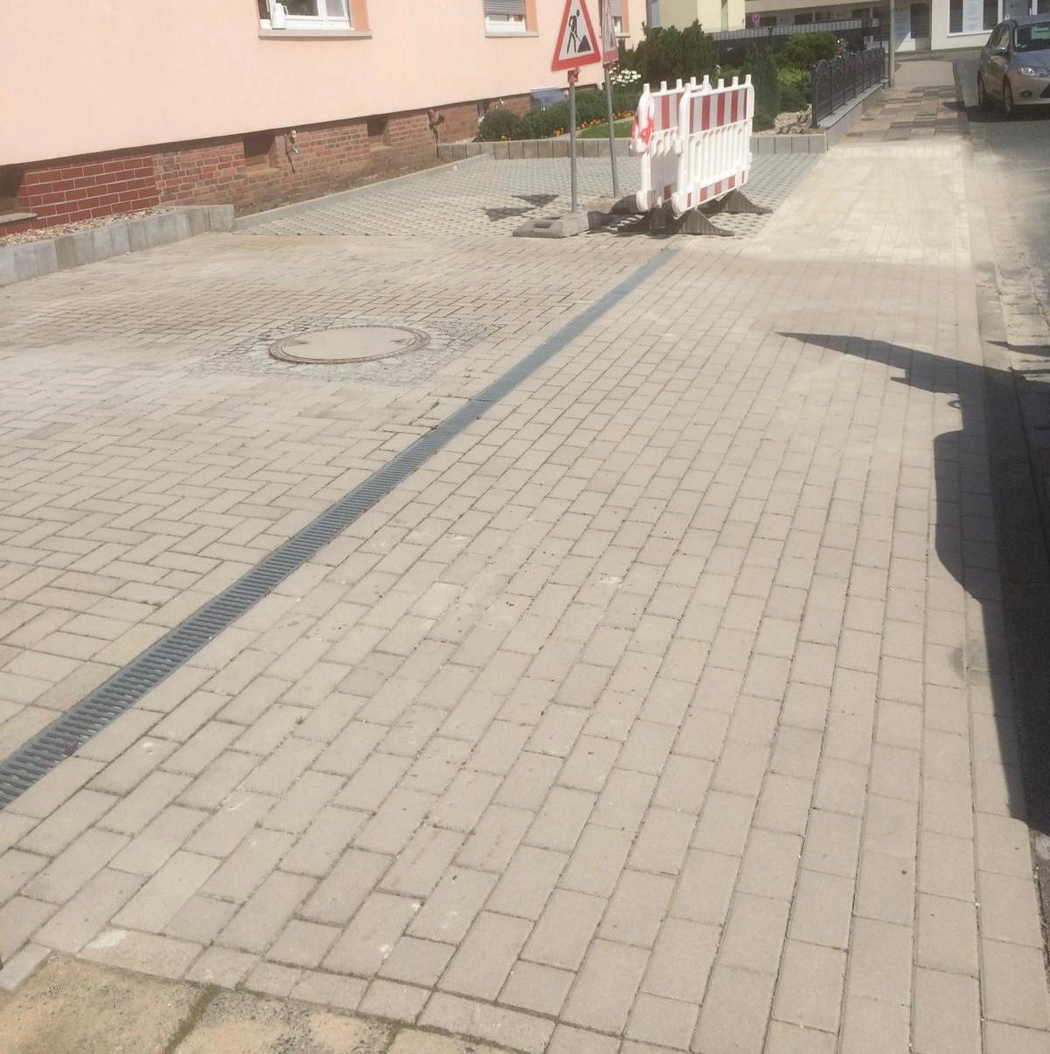Stahlke – Tief und Landschaftsbau – eine neu installierte, mit grauen Betonsteinen gepflasterte Auffahrt.
